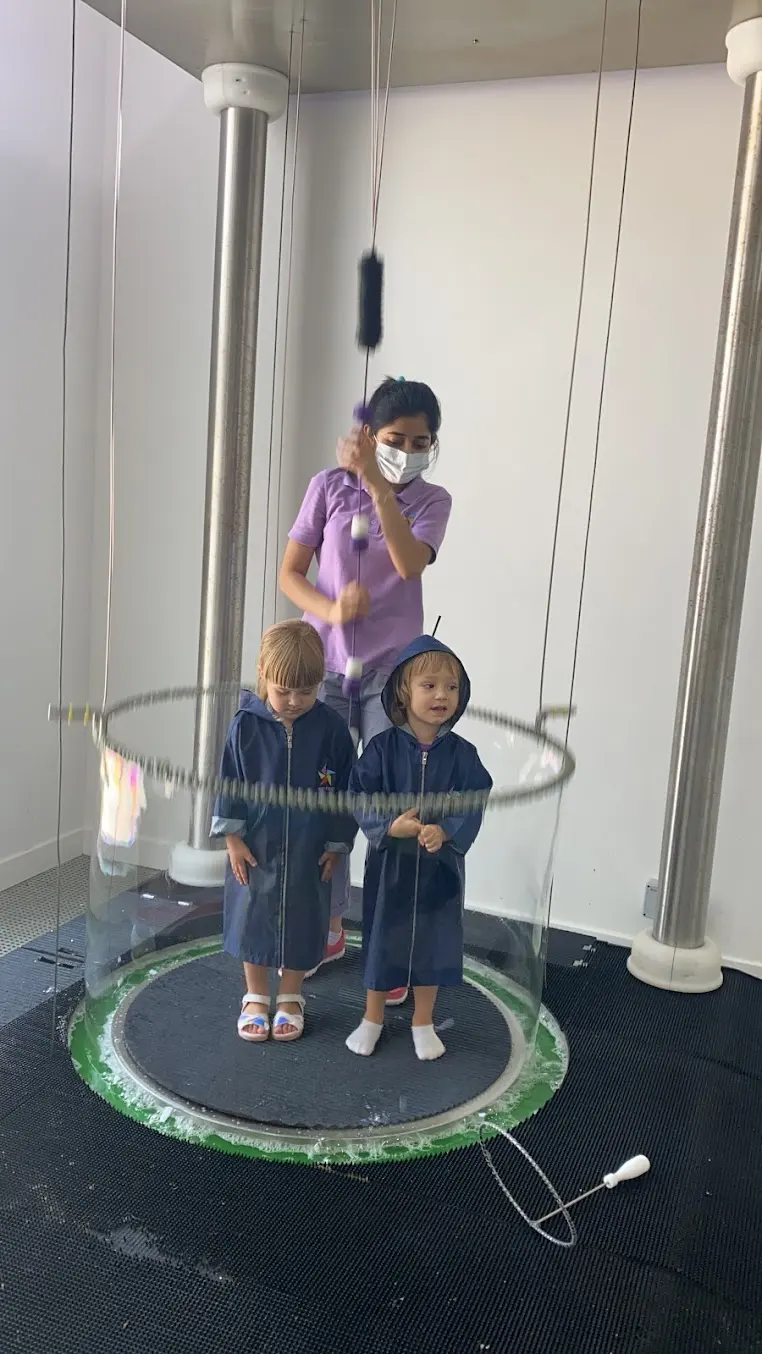 Giant soap bubble rising around a visitor at the Bubble Monster