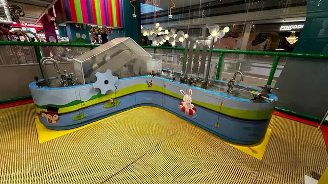 Compact interactive water table in an indoor play area