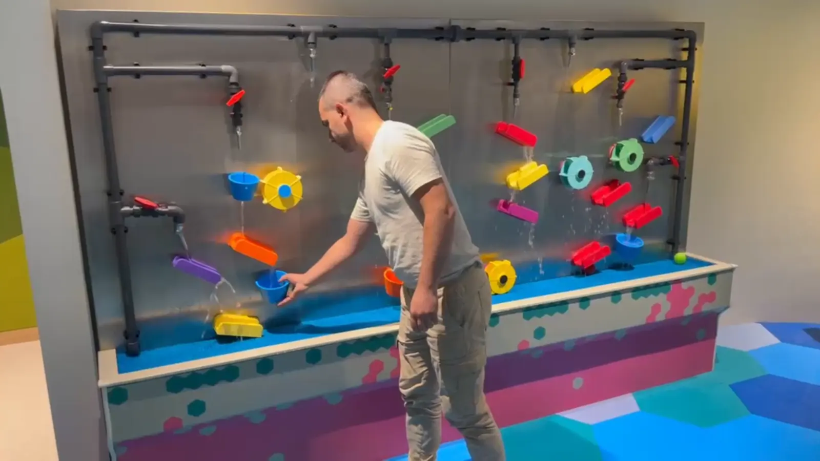 Magnetic water wall exhibit with movable channels and wheels