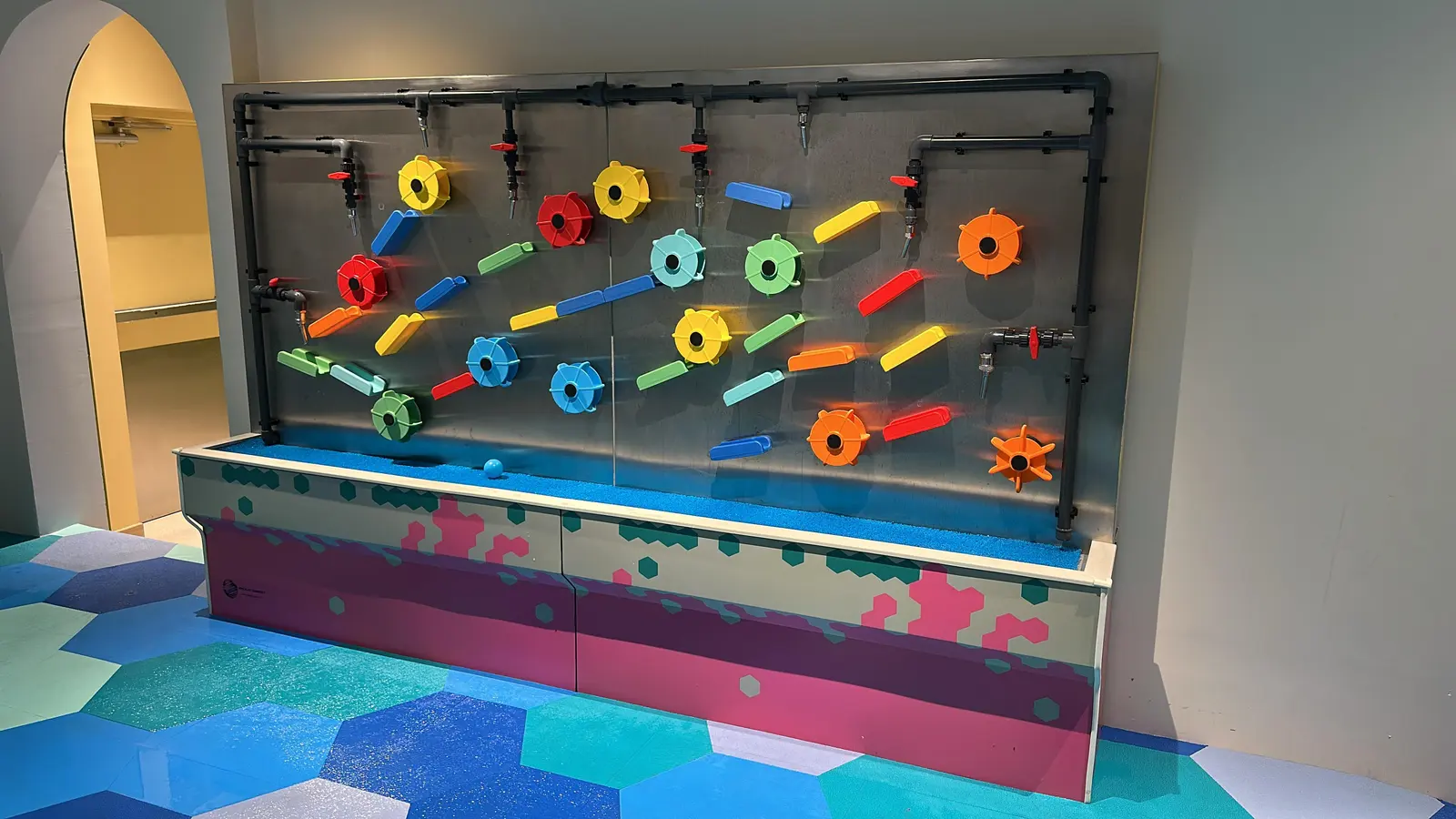 Child building a waterway on the Magnetic Water Wall