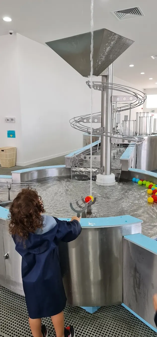 Overhead ball transport track above interactive water tables